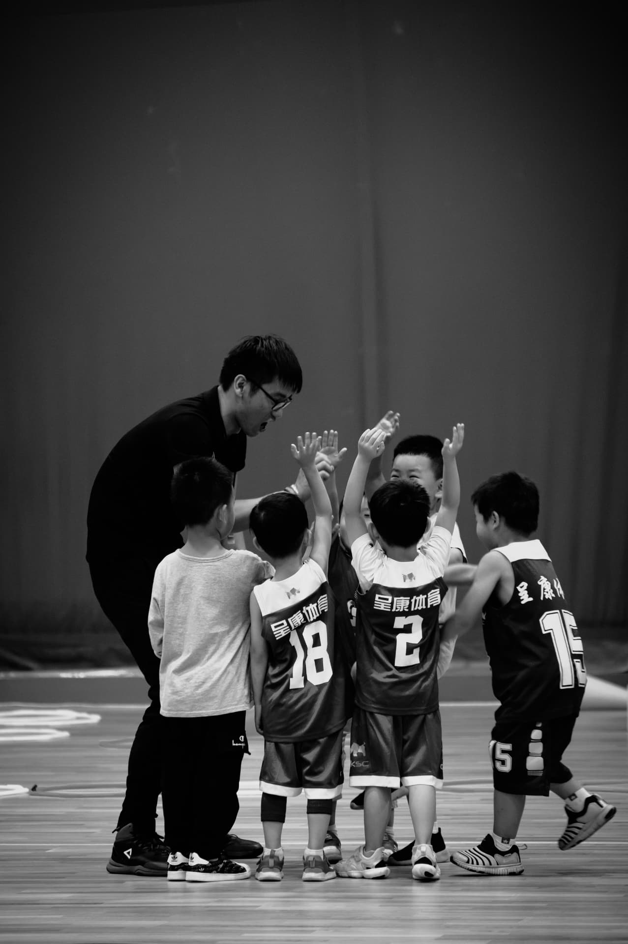 A coach talking to a youth team in a huddle
