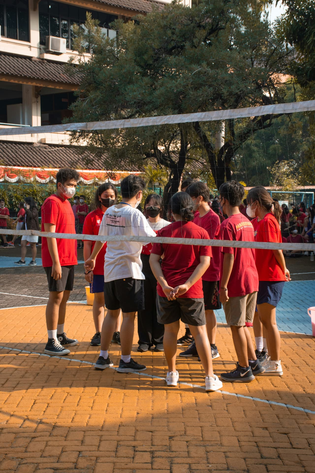 A youth team gathered at the net before a match